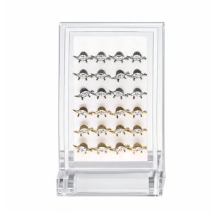 Retail-ready acrylic display case featuring 24pcs G23 titanium stegosaurus labret studs in silver and gold tones arranged in neat rows for body jewelry merchandising.