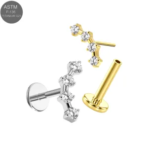 ASTM F-136 implant grade titanium threadless flat back labret ear piercing studs displaying an arched low-profile cluster top handset with four clear round brilliant CZ crystals, in plain titanium and Gold PVD variants.